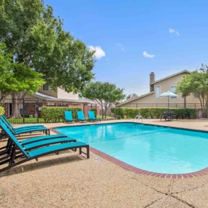 Galleria's pool with bright teal pool lounge furniture and blue skies